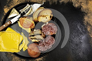 Round plate with sandwiches with fish, sausage and cheese on the meat table, top view