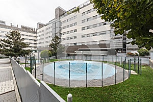 Round pool with canvas cover in communal area with fenced garden