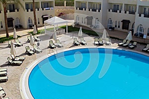 Round pool at hotel resort, with chaise-longues photo