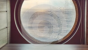 Round porthole of a sea cruise ship with water jets outside. Concept of sea travel