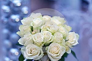 Round posy of fresh white roses over blue