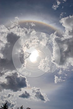 Round rainbow with Sun and clouds