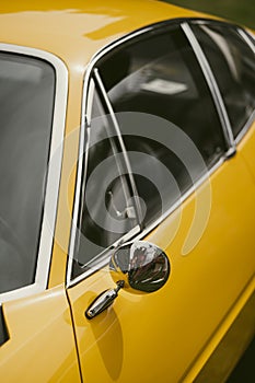 Round rear view mirror on a vintage yellow car