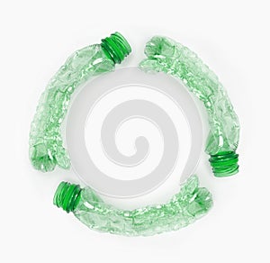 Round recycling icon from empty green plastic bottles on white background. Waste recycling concept. Garbage. Isolation on white.