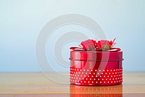 Round red gift box with ribbon bow on wooden table with copy spa