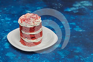 Round red velvet cake with cream on white plate