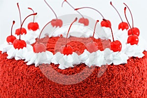 Round red velvet cake decorated with canned cherries