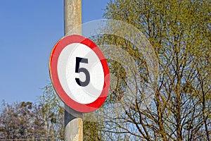 Round road speed limit sign on the pole