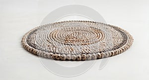 A round rug made of rope in neutral beige and grey color