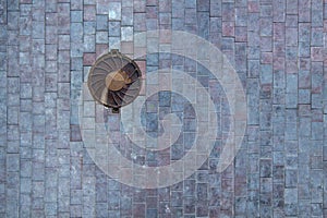 Round rusty manhole on stone paving, top view. rough texture surface