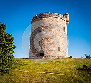 Round shaped, small, stone built, castle on plot of countryside land.