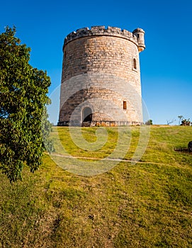 Round shaped, small, stone built, castle on plot of countryside land.