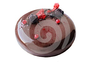 Round shiny chocolate cake with berries on white background