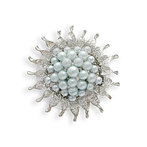 Round silver brooch with blue pearls isolated on white