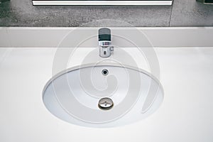 A round sink for washing hands and an automatic faucet for water in a public toilet