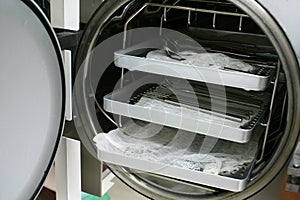 Round steam steriliser (autoclave) chamber loaded with unwrapped instruments