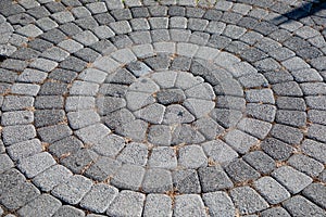 Round stone pavement pattern. Sidewalk tiles laid out from the center.