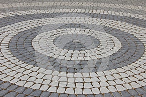 A round stone pavement pattern. Sidewalk tiles laid out from the center.