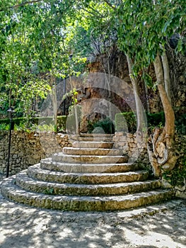 Round stone stairs in natural landscape with stone walls
