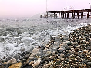 Round stones and clear sea with some waves.