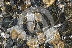 Round stones close-up in the water. Etching of water