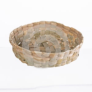 round straw craft basket on white background