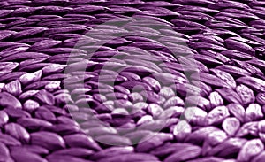 Round straw mat texture with blur effect in purple tone.