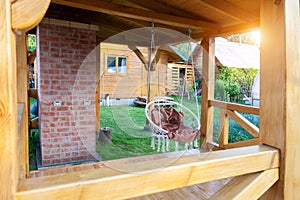 Round swinging chair in the gazebo outdoors. Summer