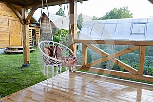 Round swinging chair in the gazebo outdoors. Summer