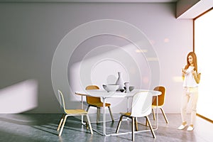 Round table dining room, woman with smartphone