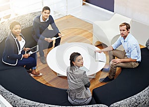 The round table of success. High angle portrait of a group of colleagues having a meeting around a table in a modern