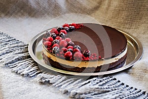 round tart with cashew cream, dark chocolate and frozen fruits photo