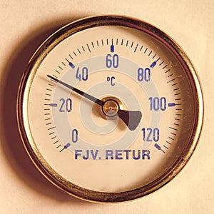 A round temperature meter on the returning water to a district heating system