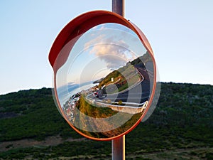 Round traffic mirror reflecting street and city