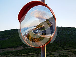 Round traffic mirror reflecting street and city