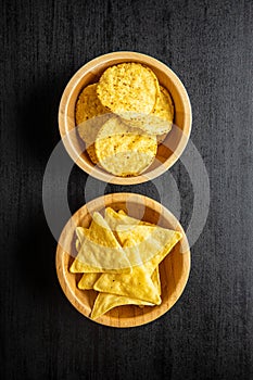 Round and triangular nacho chips. Yellow tortilla chips