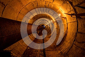 Round underground technical tunnel of heating duct with rusty pipeline