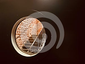 Round viewing window in the door. A window in a prison cell