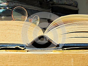Round vintage glasses laying on an old open book