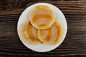 Round wafers in plate on wooden table. Top view