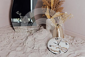 Round wall clock. Clock hands and dial. On the sand.