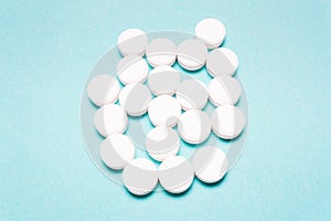 Round, white pills on a blue background