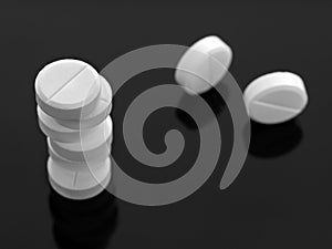 Round white pills stacked in a stack. Two are located further.
