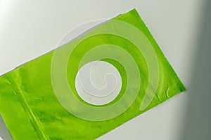 Round white sticker on green poly mailer envelope