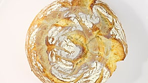 Round white whole bread rotation, turning counterclockwise, on white background, top view.