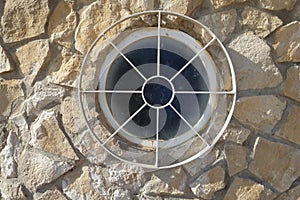 Round window with a circular metal grill