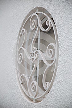 Round window and grill on white wall