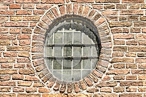 Round window in an old brick wall