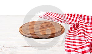 Round wood pizza cutting board and red napkin on wooden table isolated on white background. Top view and copy space, Empty