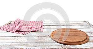 Round wood pizza cutting board and tablecloth on wooden table isolated on white background. Top view and copy space, Empty and